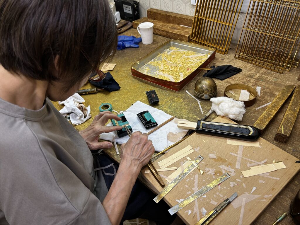 当店工場内での金箔押し風景です。坊頭位牌の仕上げに入っています。